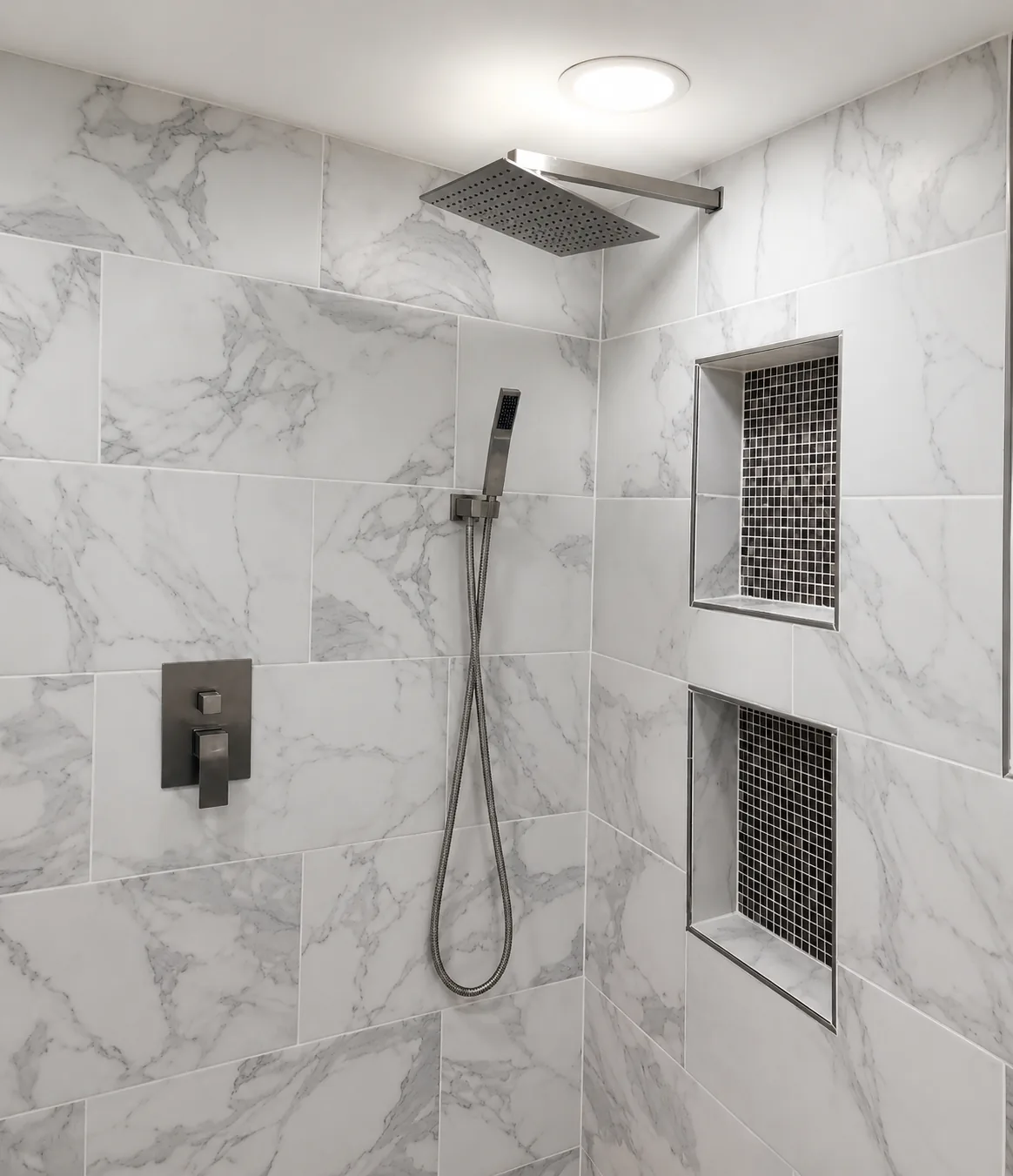 Marble tile shower with rainfall shower head and mosaic tile niches