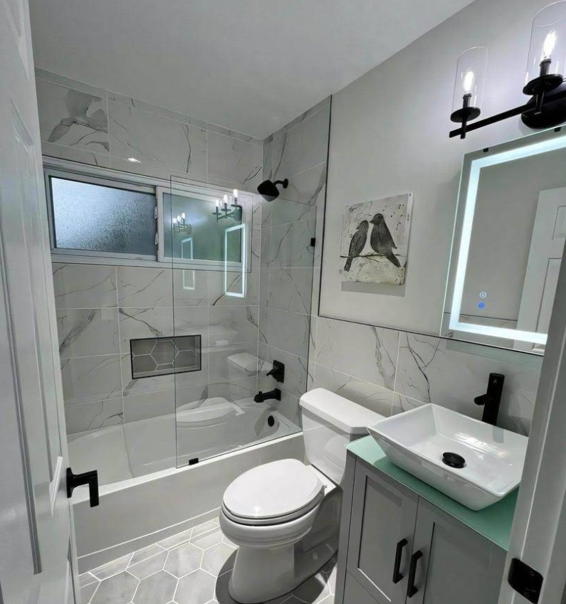 Complete bathroom remodel with marble tile and glass shower