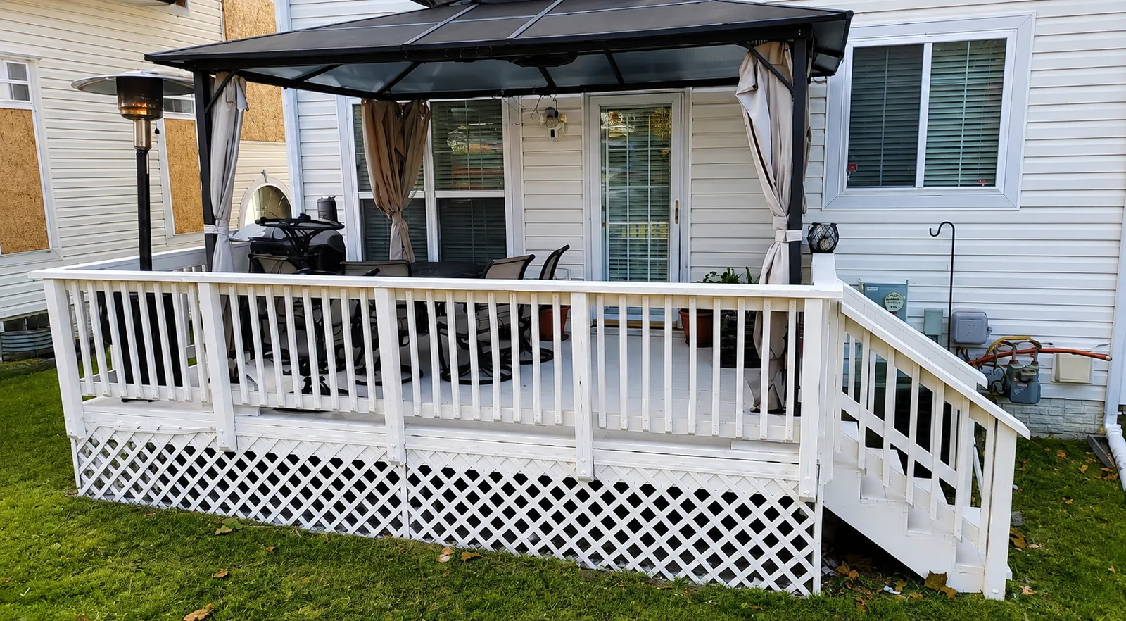 Covered backyard deck with white railings, lattice skirting, and pergola shade structure by DMV Home Improvement LLC in Washington, D.C.