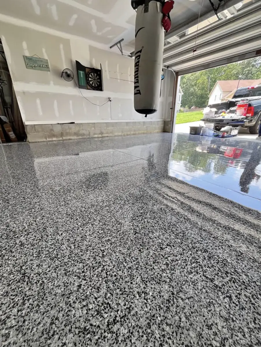 Garage floor coated with gray and black flake epoxy, finished to a high gloss