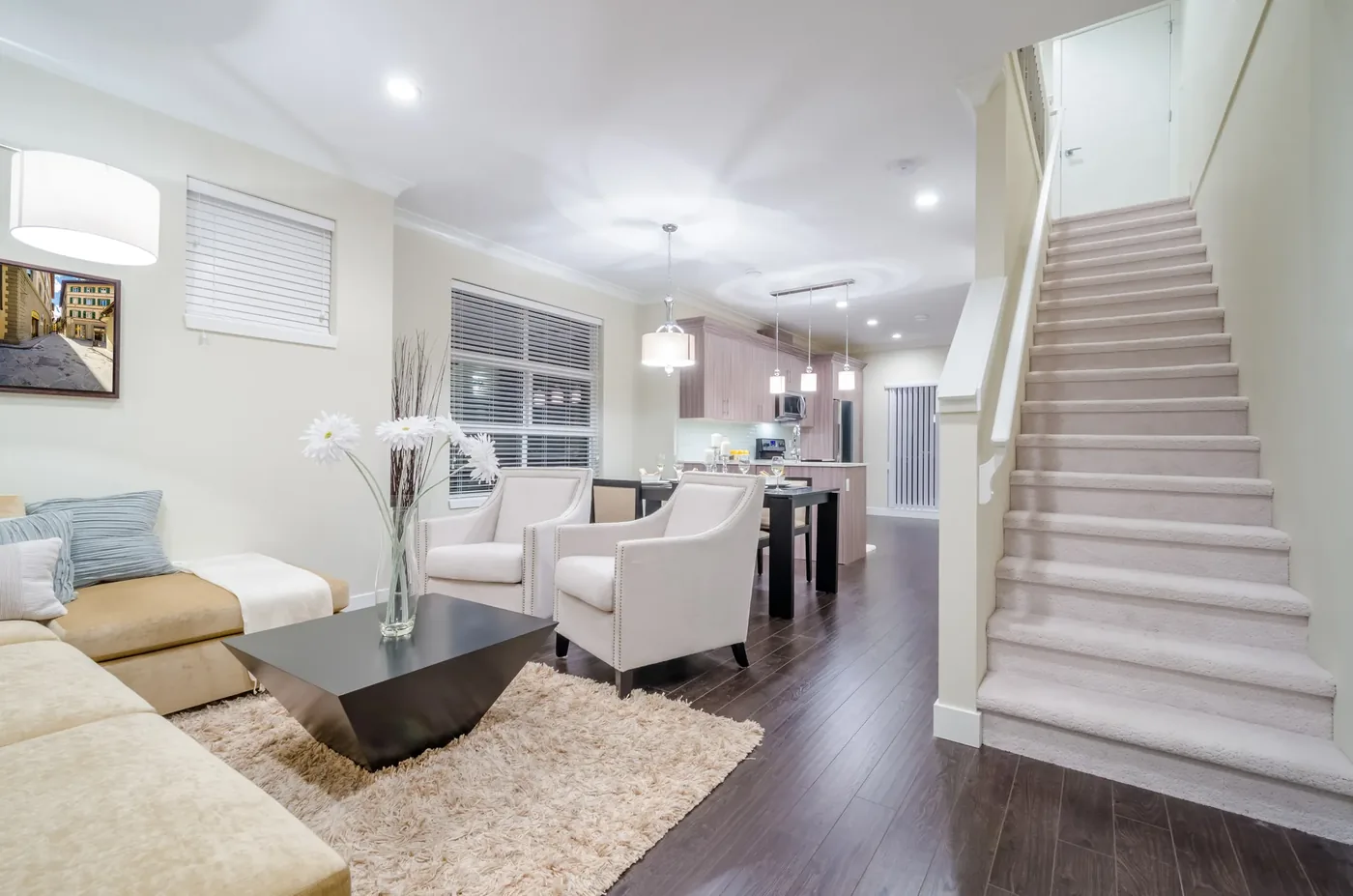 Open main floor with the kitchen beyond and a stair core rising to the level above