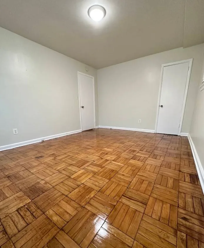 Refinished parquet hardwood flooring in a freshly painted bedroom