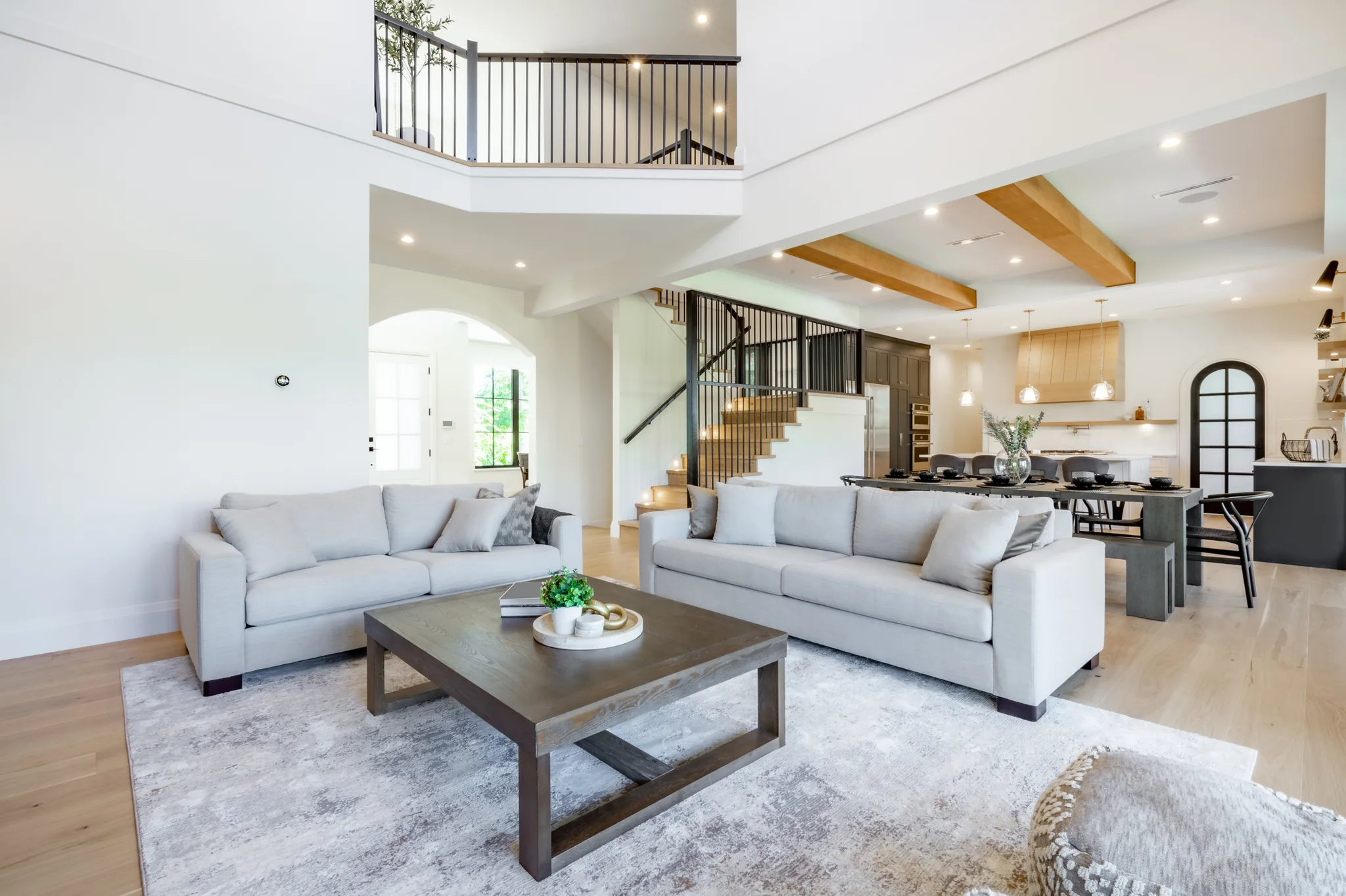 Grand two-story living room with open floor plan and wood beams