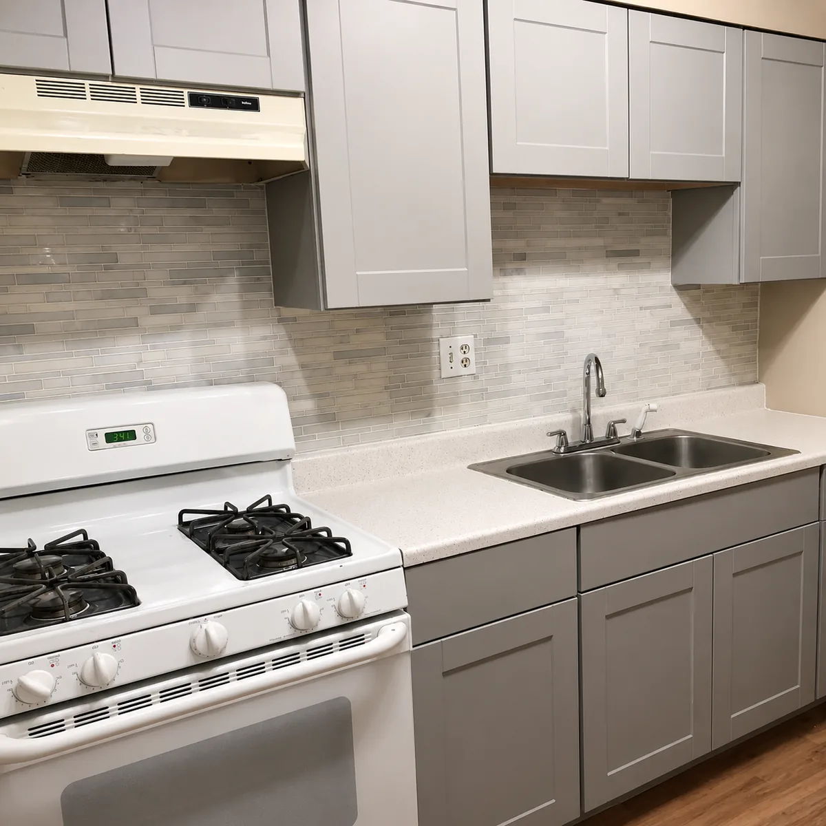 Kitchen remodel with gray shaker cabinets, tile backsplash, and gas range