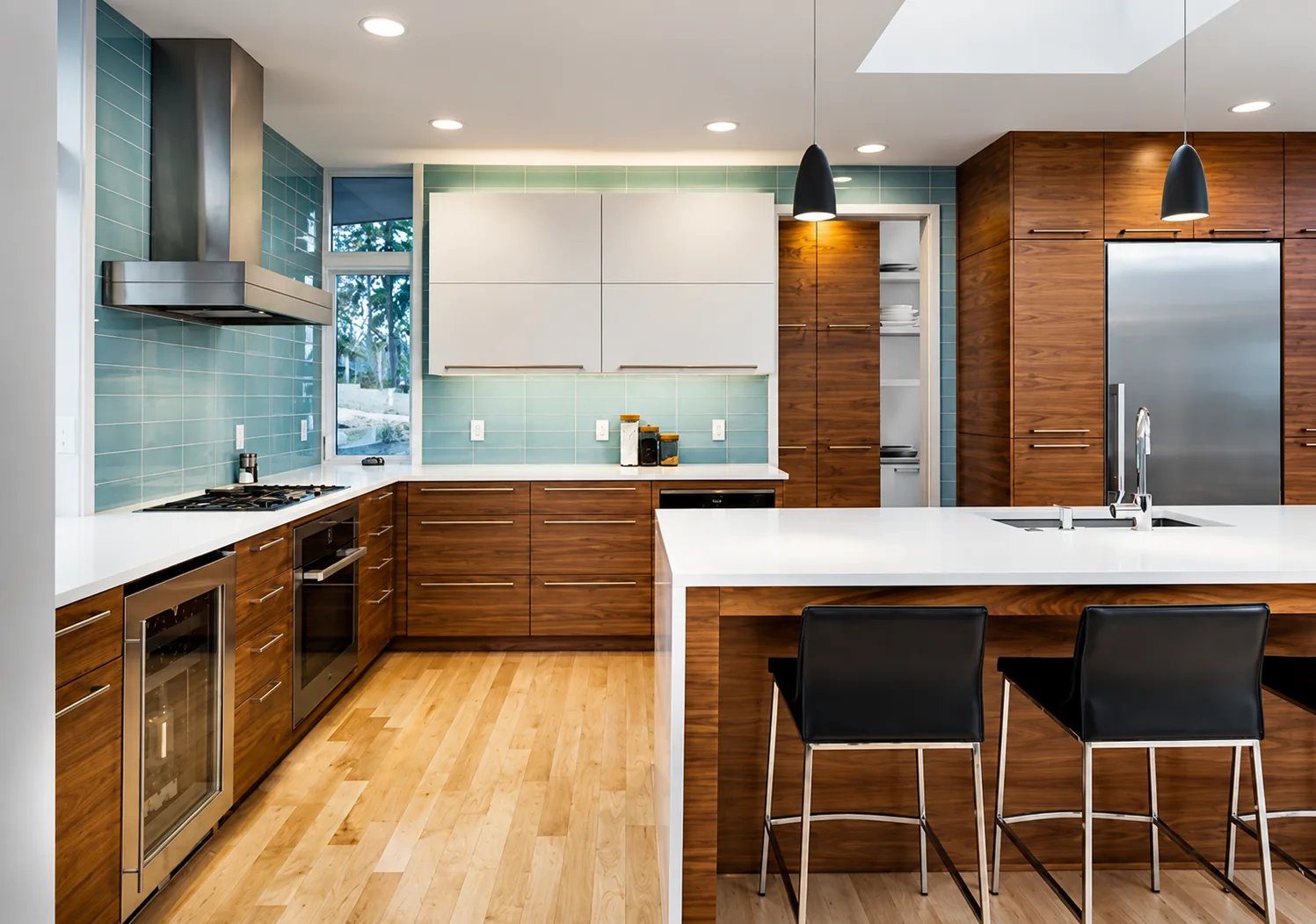 Kitchen remodel with walnut cabinetry, teal glass backsplash, and white island seating by DMV Home Improvement LLC in Washington, D.C.
