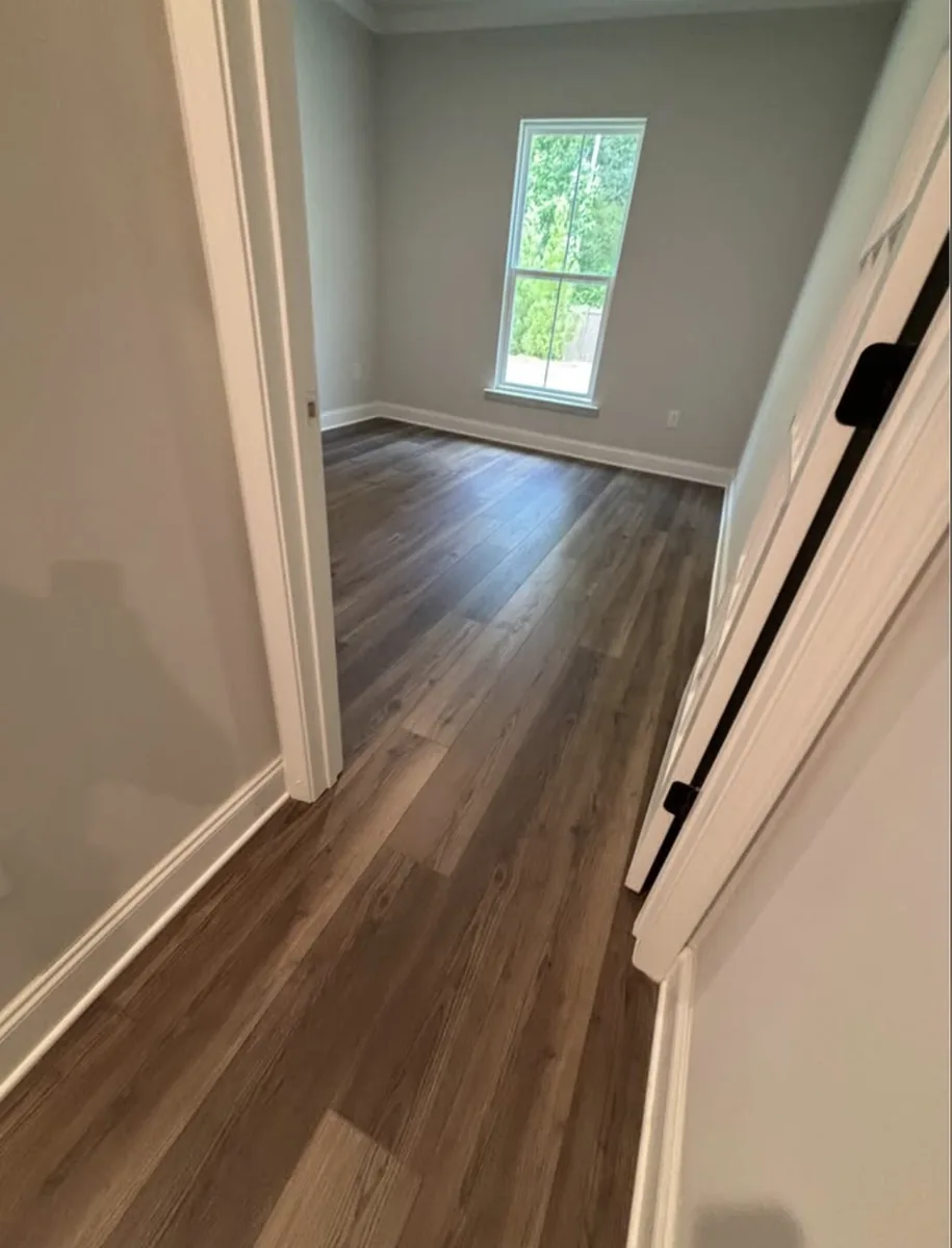 Luxury vinyl plank flooring installed through a hallway into a bedroom